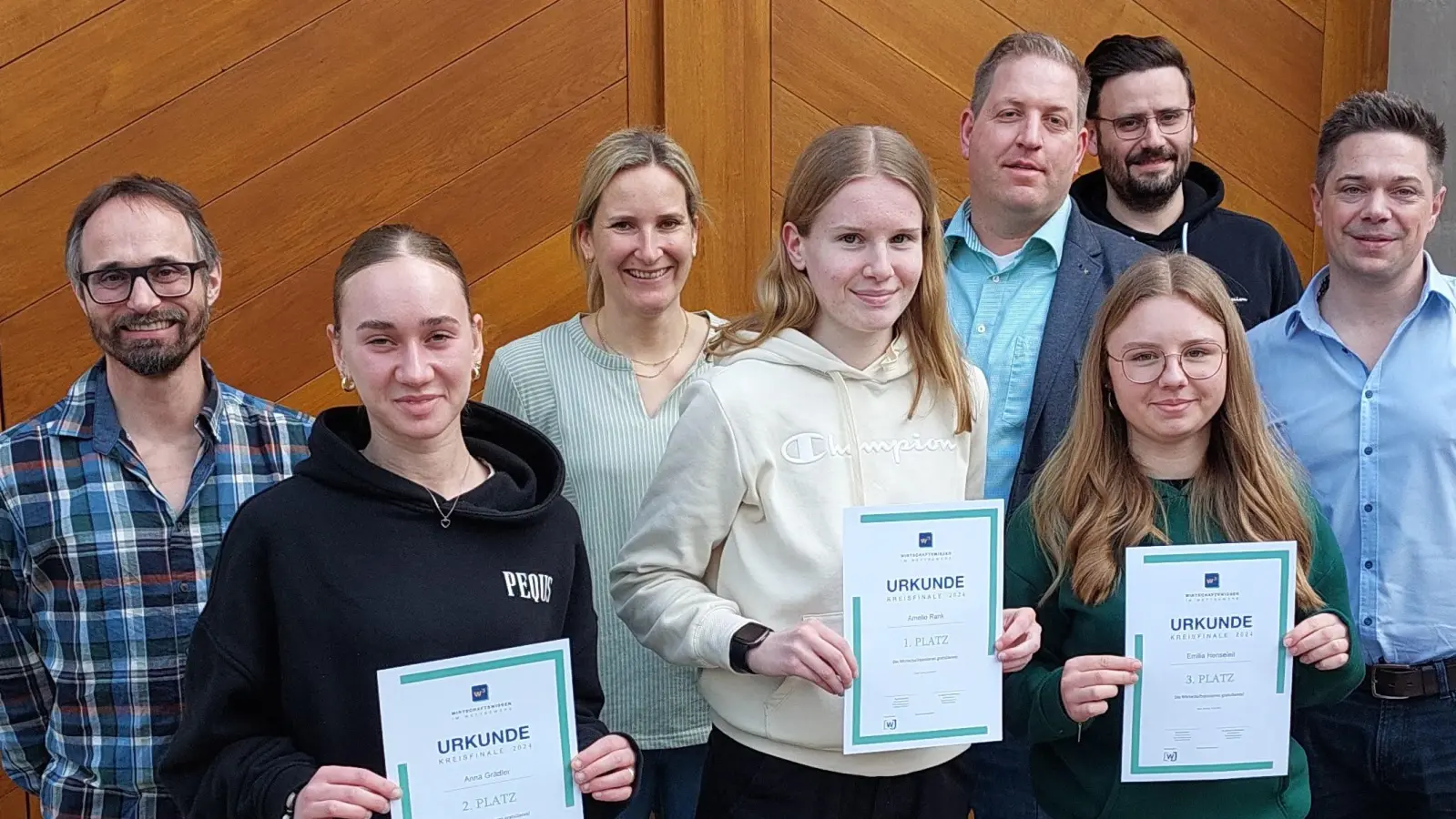 Nach der Siegerehrung zum Wirtschaftsquiz: Die drei Gewinnerinnen (vorne, von links) Anna Grädler, Amelie Rank und Emilia Henseleit mit Vertretern der Schulen und Wirtschaftsjunioren (hinten, von links) Jochen Tuchbreiter, Katharina Fruntke, Markus Zierhut, Roman Edel und Sebastian Renners.<br><br><br> (Bild: Theresia Wissinger/exb)