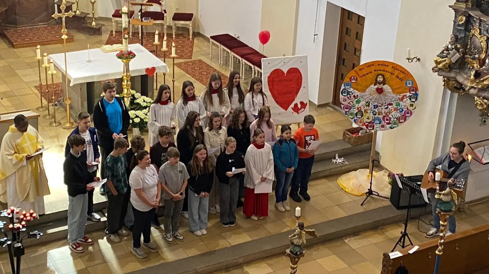 In Begleitung von Gitarristin Marie Hummer und der Gesamtleitung von Kirchenpflegerin Nicola Hummer sangen die Minis und Pfarrvikar Basil zu Ehren der Mütter ein Lied. (Bild: Nicola Hummer)