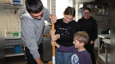 Papa, Mama und der Nachwuchs erstmals beim Butterstampfen der Siedlergemeinschaft Feuerhof zum Erntedankfest dabei. Damit die Tradition auch in Zukunft bestehen bleibt wird fleißig geübt. (Bild: Anton Fenk)