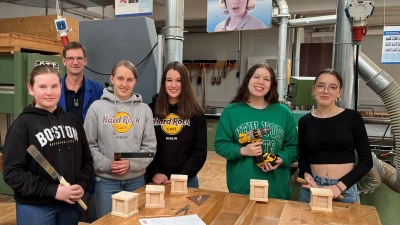 Strahlende Gesichter in der Schreinerwerkstatt: Als Andenken für Zuhause fertigten die Schülerinnen ein Würfelspiel an, Ausbilder Josef Greiner half ihnen dabei.  (Bild: Elisabeth Dembianny)