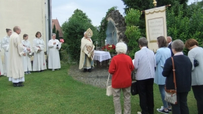Pfarrer Josef Beer spendet den Gläubigen an der Lourdesgrotte den Eucharistischen Segen. Links Diakon Edwin Berner, rechts die Fahne der Herz-Mariä-Bruderschaft und der Kirchenchor.  (Bild: Michael Götz)