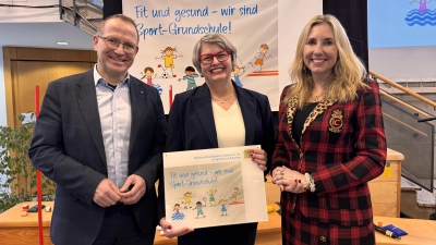 Kultusministerin Anna Stolz überreicht gemeinsam mit dem Präsidenten des Bayerischen Landes-Sportverbands Jörg Ammon die Auszeichnung als Sport-Grundschule an Rektorin Birgit Koholka (Bild: Birgit Koholka)