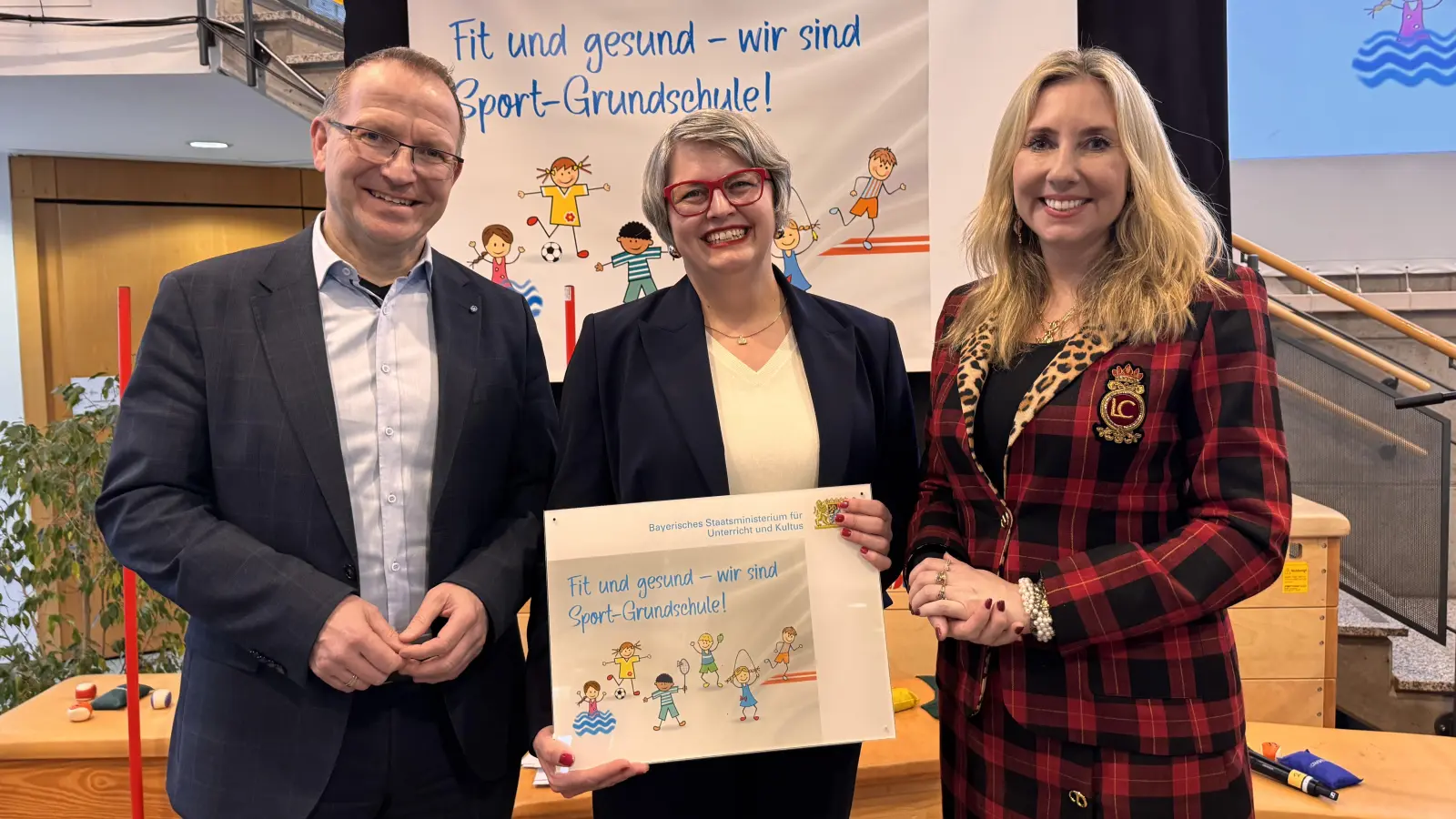 Kultusministerin Anna Stolz überreicht gemeinsam mit dem Präsidenten des Bayerischen Landes-Sportverbands Jörg Ammon die Auszeichnung als Sport-Grundschule an Rektorin Birgit Koholka (Bild: Birgit Koholka)