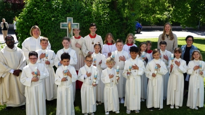 Bild: Die vierzehn Erstkommunionkinder mit Pfarrer Sagai (links), Gemeindereferentin Kathrin Blödt (2. von links), den Ministrantinnen und Ministranten, sowie den Lehrerinnen Ulrike Erlbacher (Ebermannsdorf) und Frau Lisa (?) Grabinger (Kümmersbruck) (hinten von rechts).<br> (Bild: Christine Wendl)