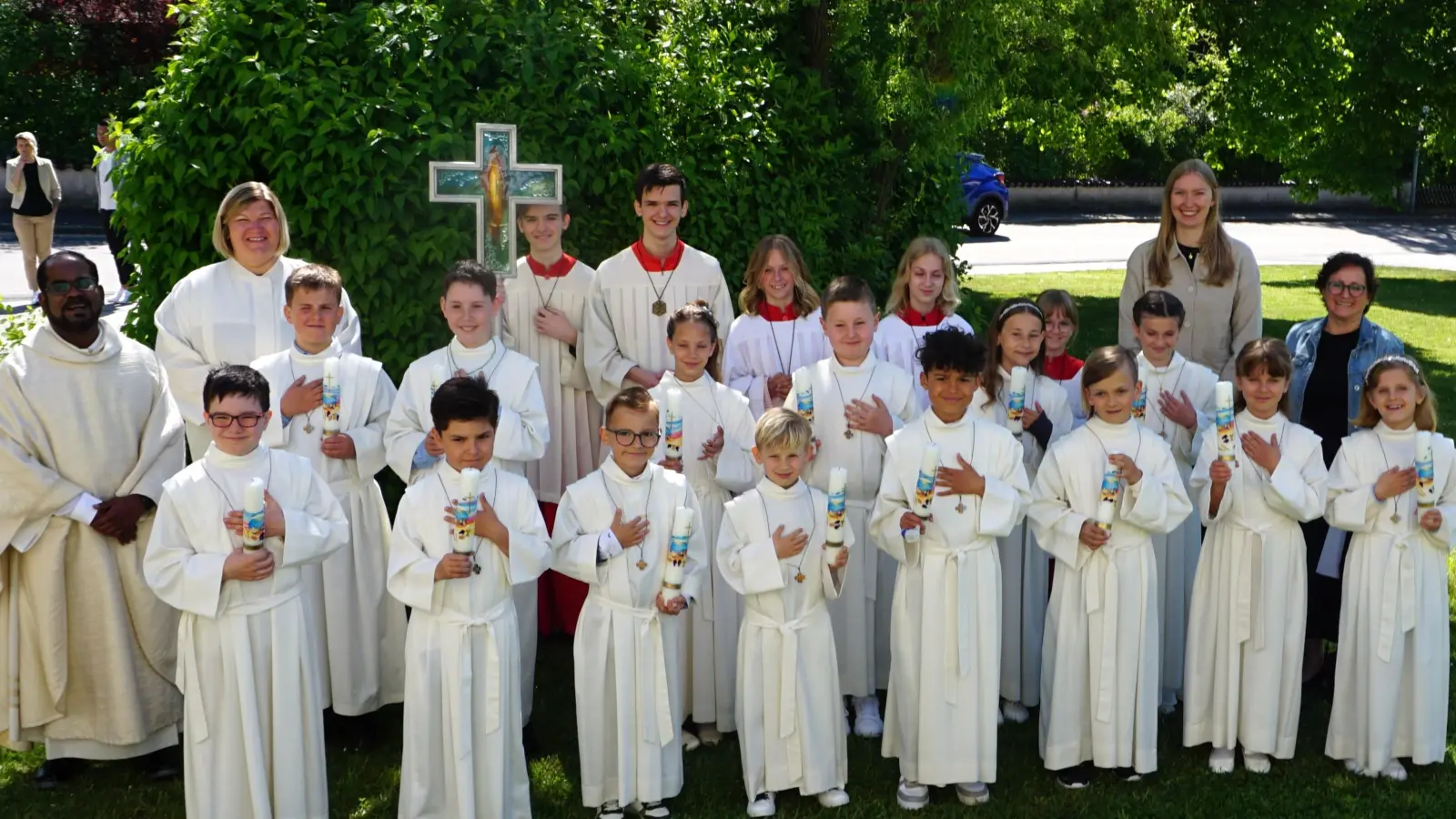Bild: Die vierzehn Erstkommunionkinder mit Pfarrer Sagai (links), Gemeindereferentin Kathrin Blödt (2. von links), den Ministrantinnen und Ministranten, sowie den Lehrerinnen Ulrike Erlbacher (Ebermannsdorf) und Frau Lisa (?) Grabinger (Kümmersbruck) (hinten von rechts).<br> (Bild: Christine Wendl)