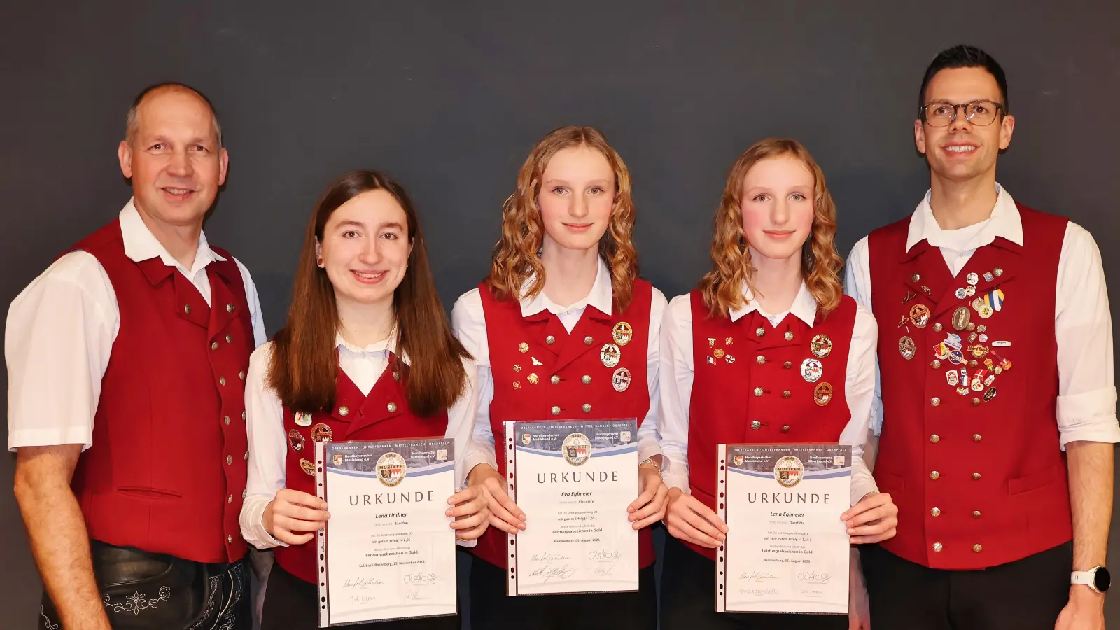 Der Vorsitzende des Musikvereins Christian Winklmann (links) und Dirigent Florian Schertl (rechts) gratulieren den neuen „Gold-Mädels“ Lena Lindner, Eva Eglmeier und Lena Eglmeier (v.l.) zum bestandenen Leistungsabzeichen. (Bild: Stefanie Gradl)