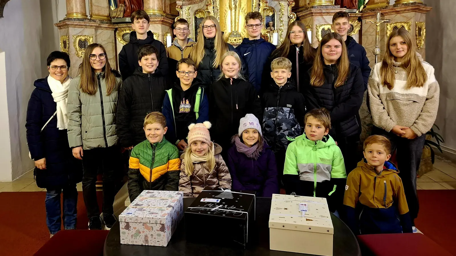 Die Ministrantengruppe Großschönbrunn mit ihren drei gepackten Päckchen. (Bild: Stephanie Lederer)