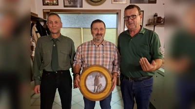 1. Schützenmeister Helmut Werner (rechts) und 2. Schützenmeister Michael Knott aus Charlottenthal übergeben die Ehrenscheibe an Josef Paa aus Schwarzach.  (Bild: Kerstin Werner)