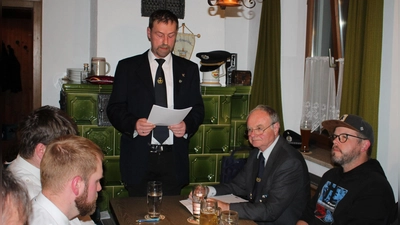 Vorsitzender Markus Reiß (stehend) und Soldatenbunds-Kreisvize Max Wagner (Zweiter von rechts) freuten sich über die nach wie vor gedeihliche Entwicklung der Burkhardsreuther Soldatenkameradschaft. (Bild: Bernhard Piegsa)