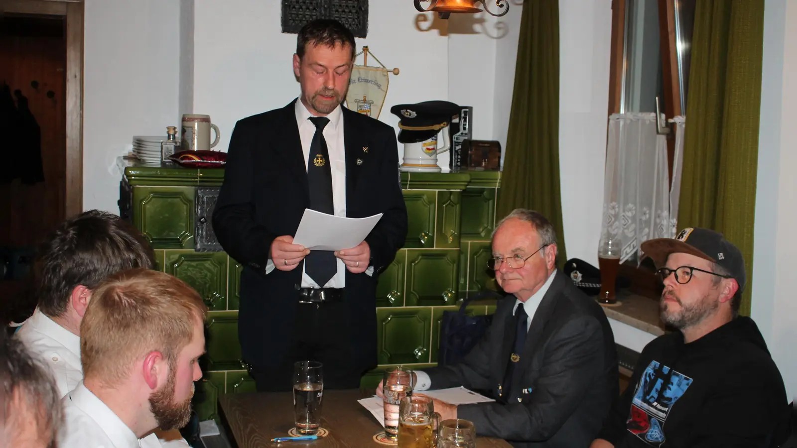 Vorsitzender Markus Reiß (stehend) und Soldatenbunds-Kreisvize Max Wagner (Zweiter von rechts) freuten sich über die nach wie vor gedeihliche Entwicklung der Burkhardsreuther Soldatenkameradschaft. (Bild: Bernhard Piegsa)