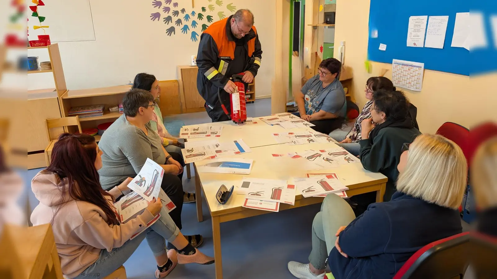 Feuerwehrkommandant Meinzinger zeigt dem pädagogischen Fachpersonal den richtigen Umgang mit dem Feuerlöscher (Bild: Karin Krenkel)
