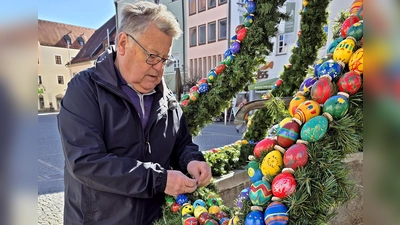Mit einem geübten Blick korrigiert Günther Magerl die Ketten, Bänder und bunten Eier am tollen Osterbrunnen vor dem „Alten Rathaus”. (Bild: Peter Ertl)