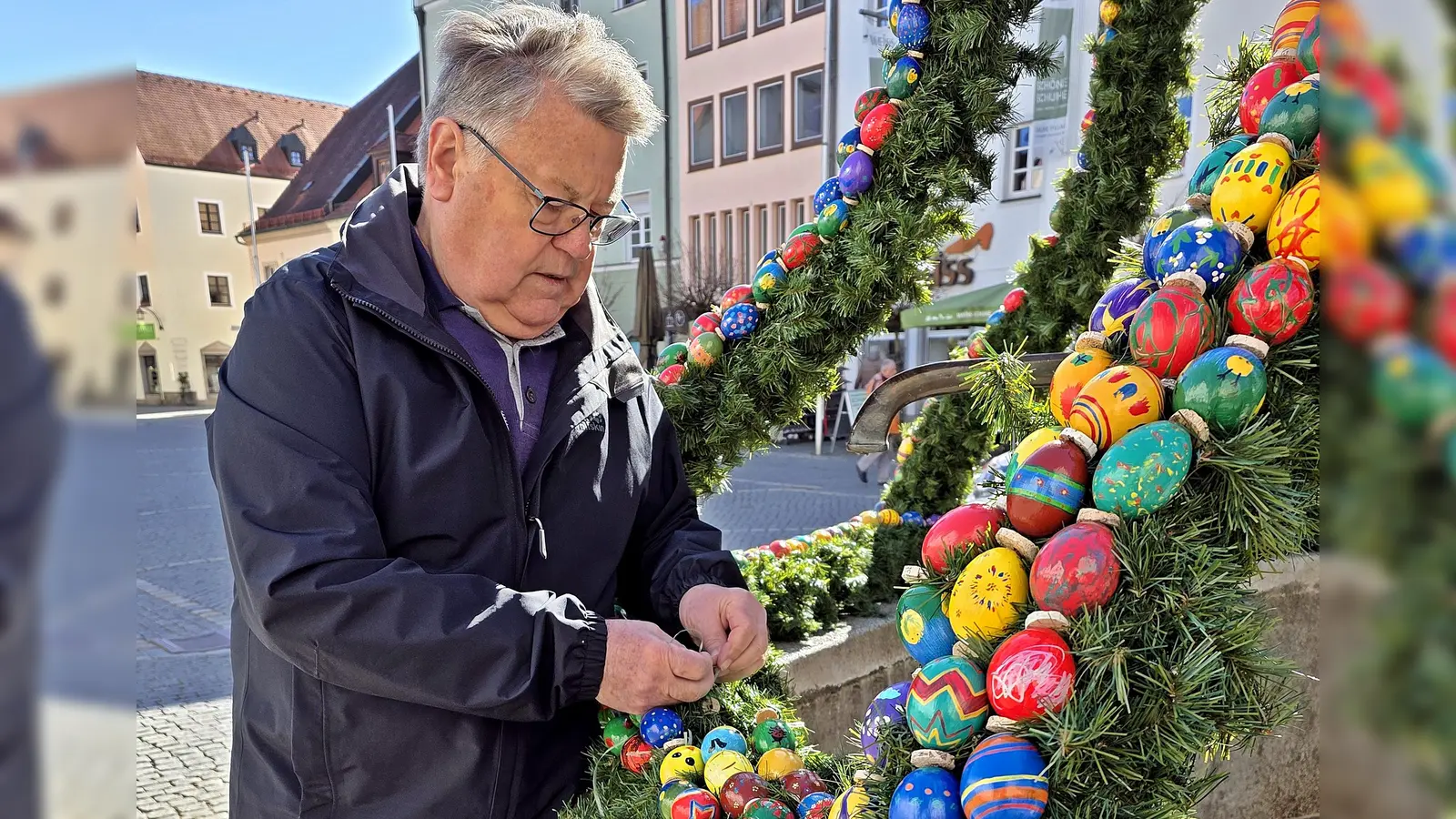 Mit einem geübten Blick korrigiert Günther Magerl die Ketten, Bänder und bunten Eier am tollen Osterbrunnen vor dem „Alten Rathaus”. (Bild: Peter Ertl)