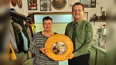 Schützenmeister Helmut Werner überreichte die Ehrenscheibe, die ein traditionsreiches Wilderermotiv zeigt, zum Saisonabschluß an die Gewinnerin Monika Ried.  (Bild: Kerstin Wild)