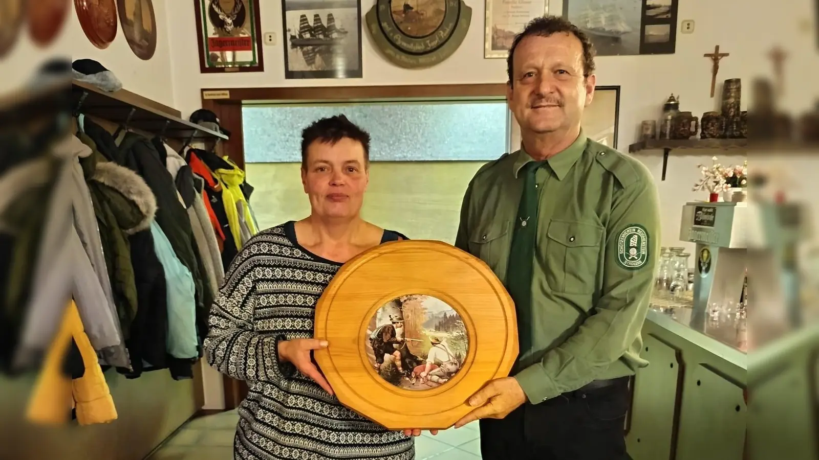 Schützenmeister Helmut Werner überreichte die Ehrenscheibe, die ein traditionsreiches Wilderermotiv zeigt, zum Saisonabschluß an die Gewinnerin Monika Ried.  (Bild: Kerstin Wild)