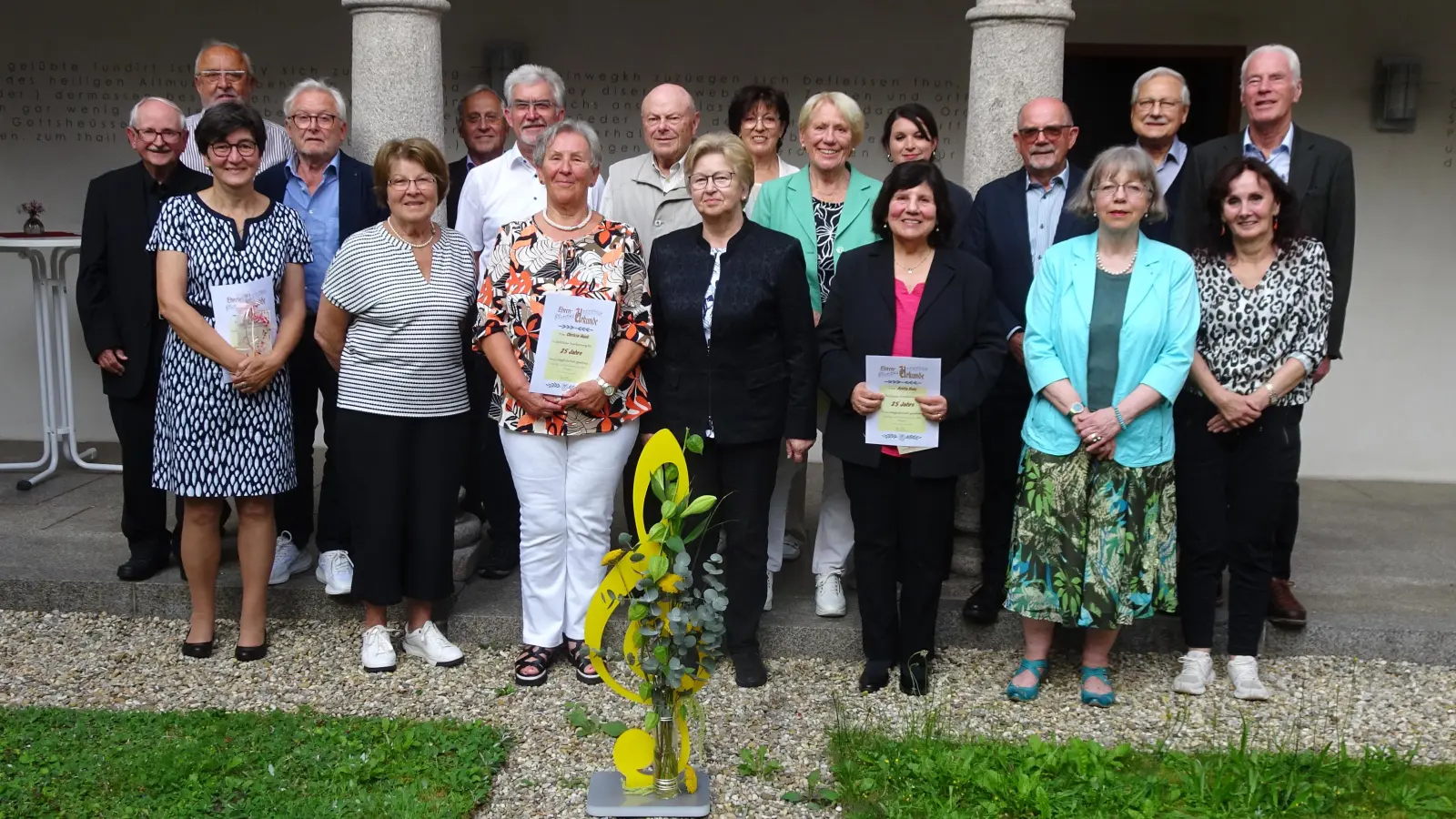 Unser Bild zeigt die geehrten Vereinsmitglieder mit den Ehrengästen und 1. Vorsitzendem Karl Prell. Im Vordergrund der Notenschlüssel, das Präsent der Sing- und Musikschule. (Bild: Alfred Hammer)