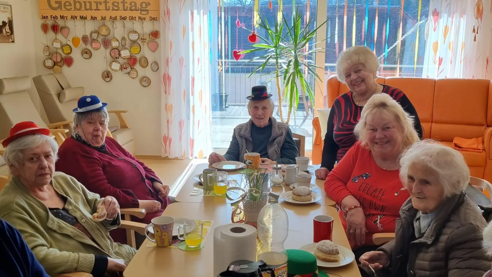 Ein gern gesehener Gast in der Tagepflegestation ist Helga Adlhoch (stehend) und besonders wenn leckere Faschingskrapfen mitgebracht werden.  (Bild: Regina Ring)