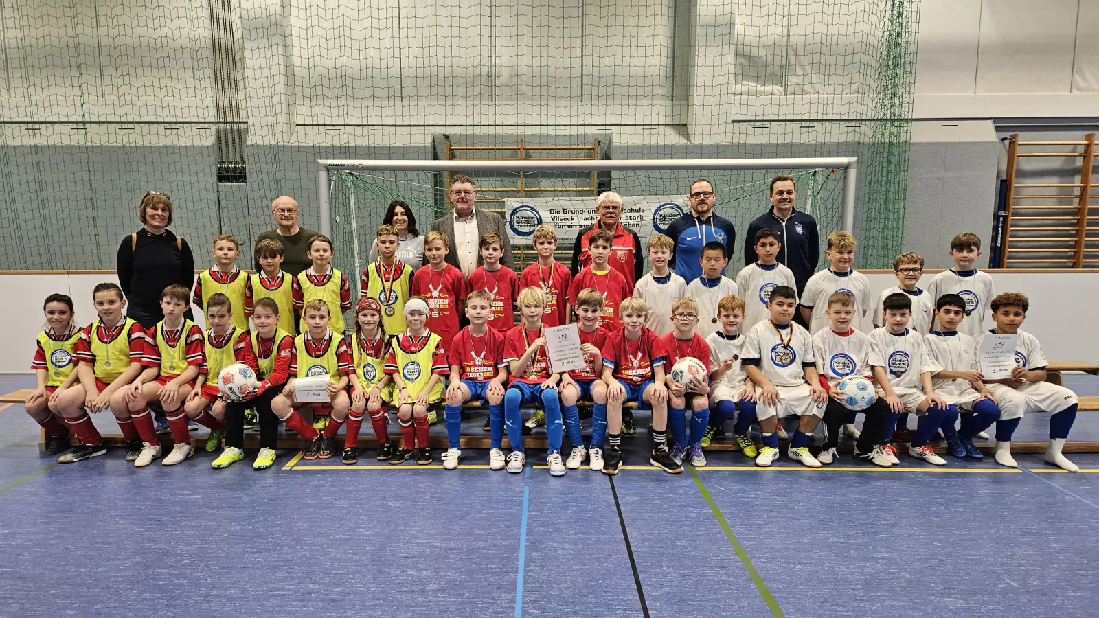 Die drei erstplatzierten Grundschul-Jungen-Mannschaften nach der Hallen-Fußball-Landkreismeisterschaft in Vilseck von links: 2. Illschwang, 1. Auerbach und 3. Vilseck I mit (hinten, von links) Studienrätin Christine Ruoff (Illschwang), Grundschul-Fußball-Obmann Karl Heinz Grollmisch, Studienrätin Maria Danninger, Bürgermeister Hans-Martin Schertl, Schiedsrichter Christian Trummer, Martin Winkler und Lehrer Alexander Merkl (beide Betreuer Vilseck). (Bild: Christine Grollmisch)