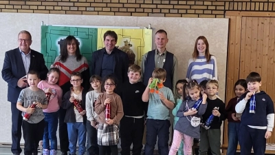 Zweiter Bürgermeister Martin J. Preuß (links), Sonderschulrektor Ralph Schmitt (Mitte) sowie Lehrkräfte und Mitarbeiter der städtischen Abfallberatung freuten sich mit den Erstklässlern über ihre neuen personalisierten Trinkflaschen.  (Bild: Elena Berschneider)