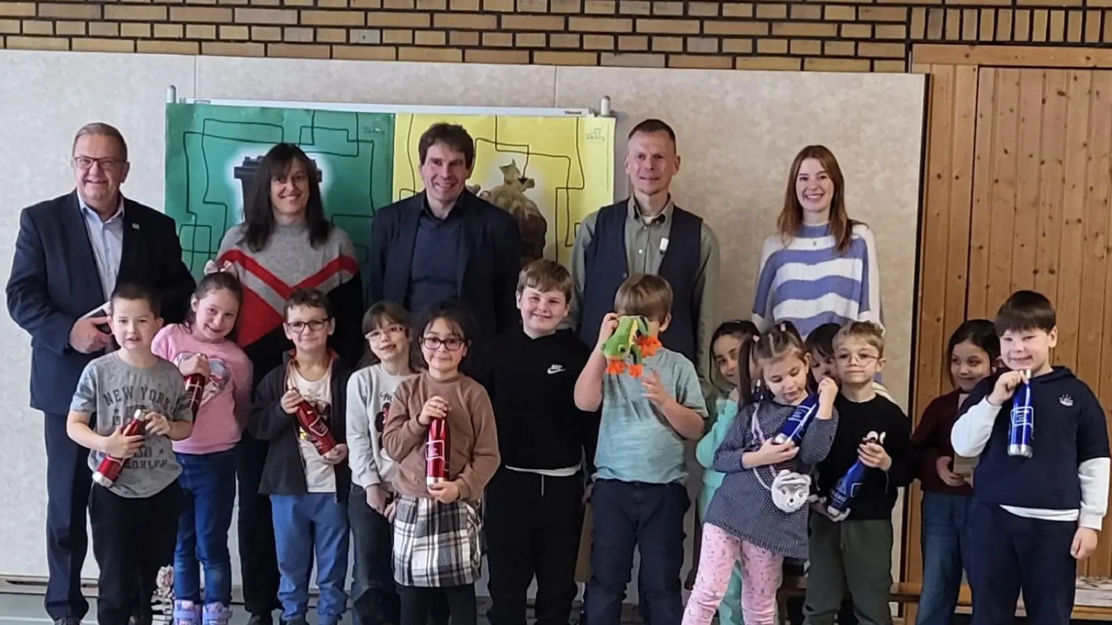 Zweiter Bürgermeister Martin J. Preuß (links), Sonderschulrektor Ralph Schmitt (Mitte) sowie Lehrkräfte und Mitarbeiter der städtischen Abfallberatung freuten sich mit den Erstklässlern über ihre neuen personalisierten Trinkflaschen.  (Bild: Elena Berschneider)