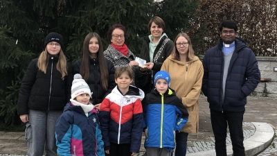 Direkt vor der Neusorger Pfarrkirche überreichten die Verantwortlichen und Kinder aus Weihermühle mit Ulrike Krauß und Sabrina Böhm an Marianne Fütterer (Bildmitte hintere Reihe) ihre Spende von 300 Euro. Pfarrvikar Arul (rechts) dankte ebenfalls im Namen der Familienhilfe. (Bild: Oliver Becher)