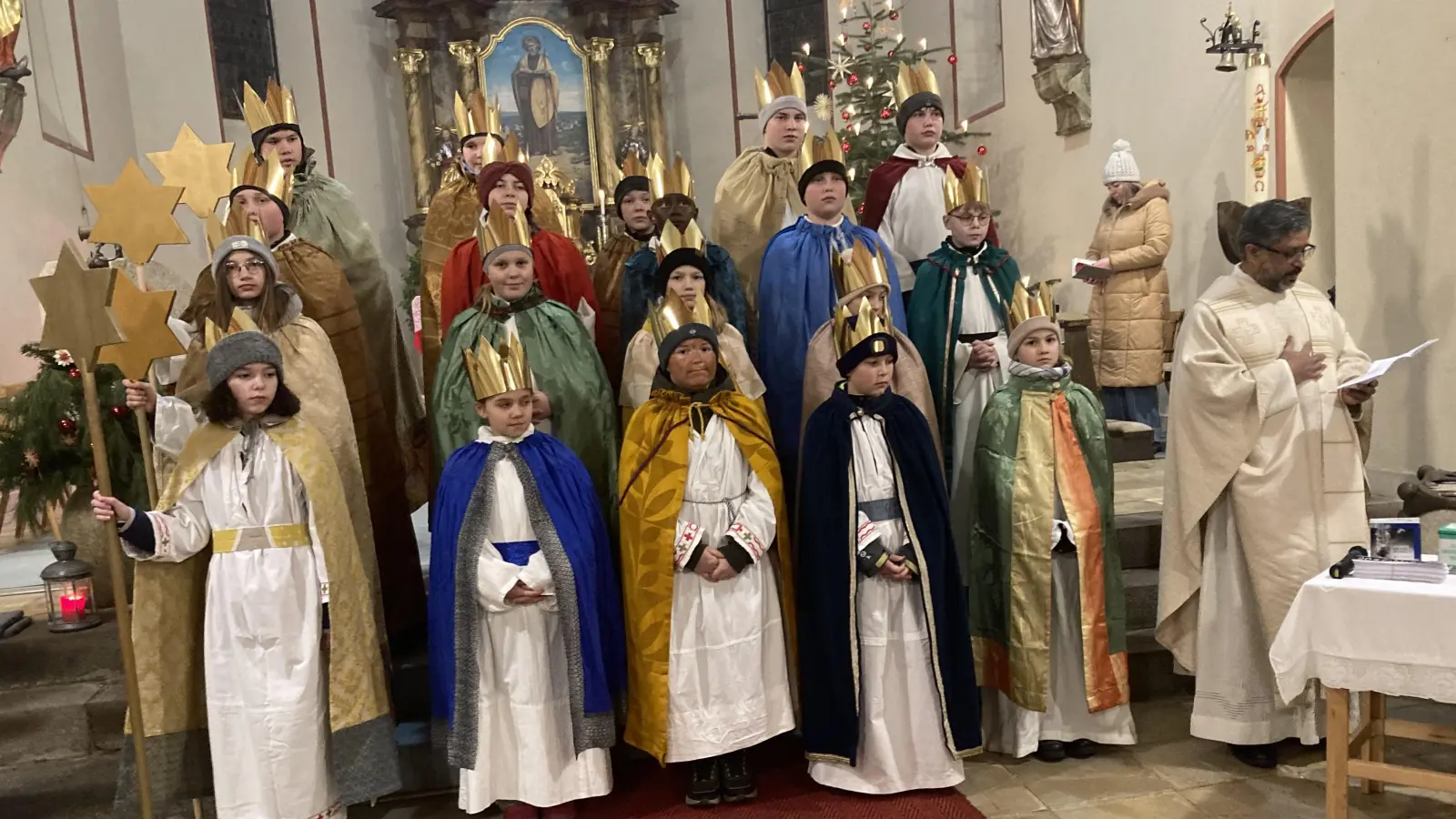 Die 19 Sternsinger der Expositur St. Jakobus und der Filialkirche St. Emmeram, die gemeinsam von Pater Jo Jovilla Kurian (rechts) ausgesandt wurden. (Bild: Sieglinde Schärtl)