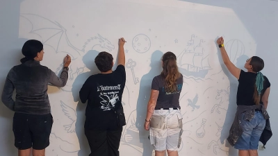 Lena Schultes (zweite von rechts) mit Schülerinnen beim Übertragen des selbst gestalteten Bildes an die Wand. (Bild: Nadine Meiler)