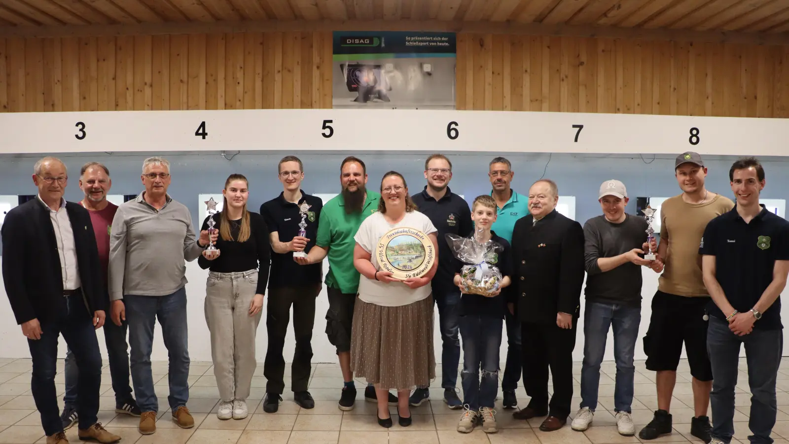 Sandra Dallmeier (7.v.l.) gewann mit einem 25-Teiler die Freundschaftsscheibe. Mit im Bild die Siegerteams sowie Riedens Bürgermeister Erwin Geitner (v.l.), Wolfsbachs Erster Schützenmeister Heiner Graf, Riedens Schützenmeister Thomas Graf (8.v.l.) und Ensdorfs Dritter Bürgermeister Roland Müller (10.v.l.). (Bild: Michael Rabenhofer)