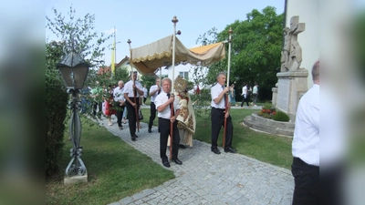 Pfarrer Josef Beer am Fronleichnamstag mit der Monstranz und unter dem Himmel auf dem Weg zum vierten Altar.  (Bild: Michael Götz)