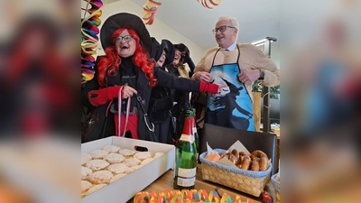 Oberhexe Helga Gebhardt überreicht Bürgermeister Bernhard Lindner ein besonderes Exemplar der Hexenschürze. (Bild: Margarete Hirsch)