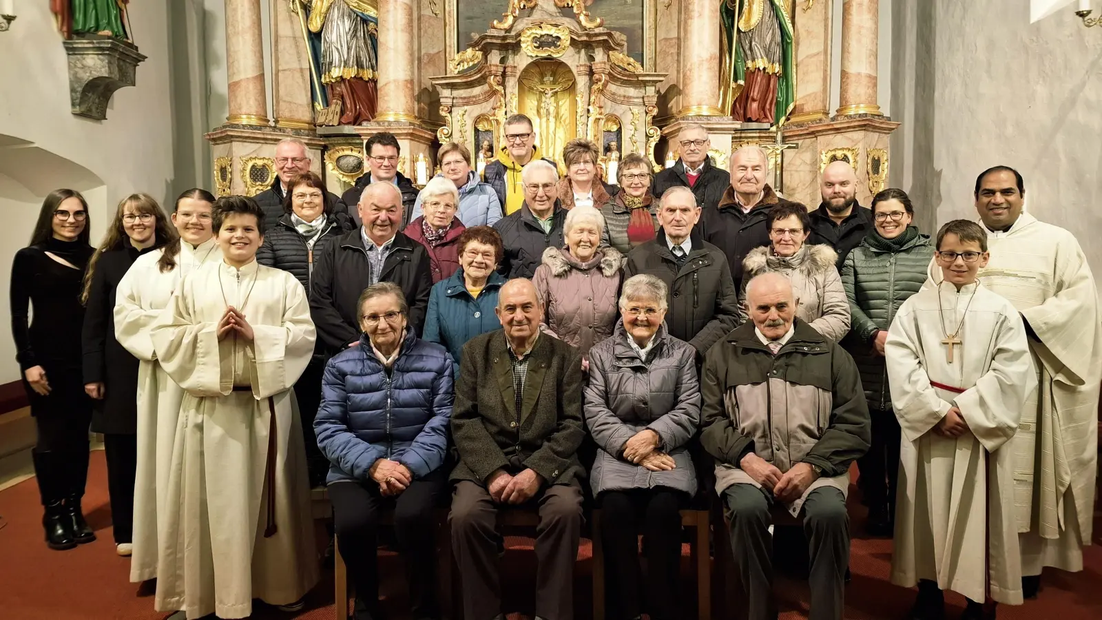 Vorne von links.: Ministrant Elias Siegert, Inge und Ottmar Iberl, Anna und Justin Zeinz, Ministrant Christoph Lederer. Zweite Reihe von links: Ministrantin Helena Lederer, Georg und Annelies Dotzler, Kunigunda und Bartholomäus Prechtl, Erna Schwirzer, Veronica Rettinger. Dritte Reihe von links:: Musikerinnen Sophie Lederer und Michaela Stauber, Inge Schwirzer, Inge und Konrad Lederer, Elsa Siegert, Heinrich Schwirzer, Dominik Rettinger. Hinten von links.: Christian Schwirzer, Thomas und Martina Gebhard, Markus und Petra Bauer, Hans Siegert. (Bild: Stephanie Lederer)
