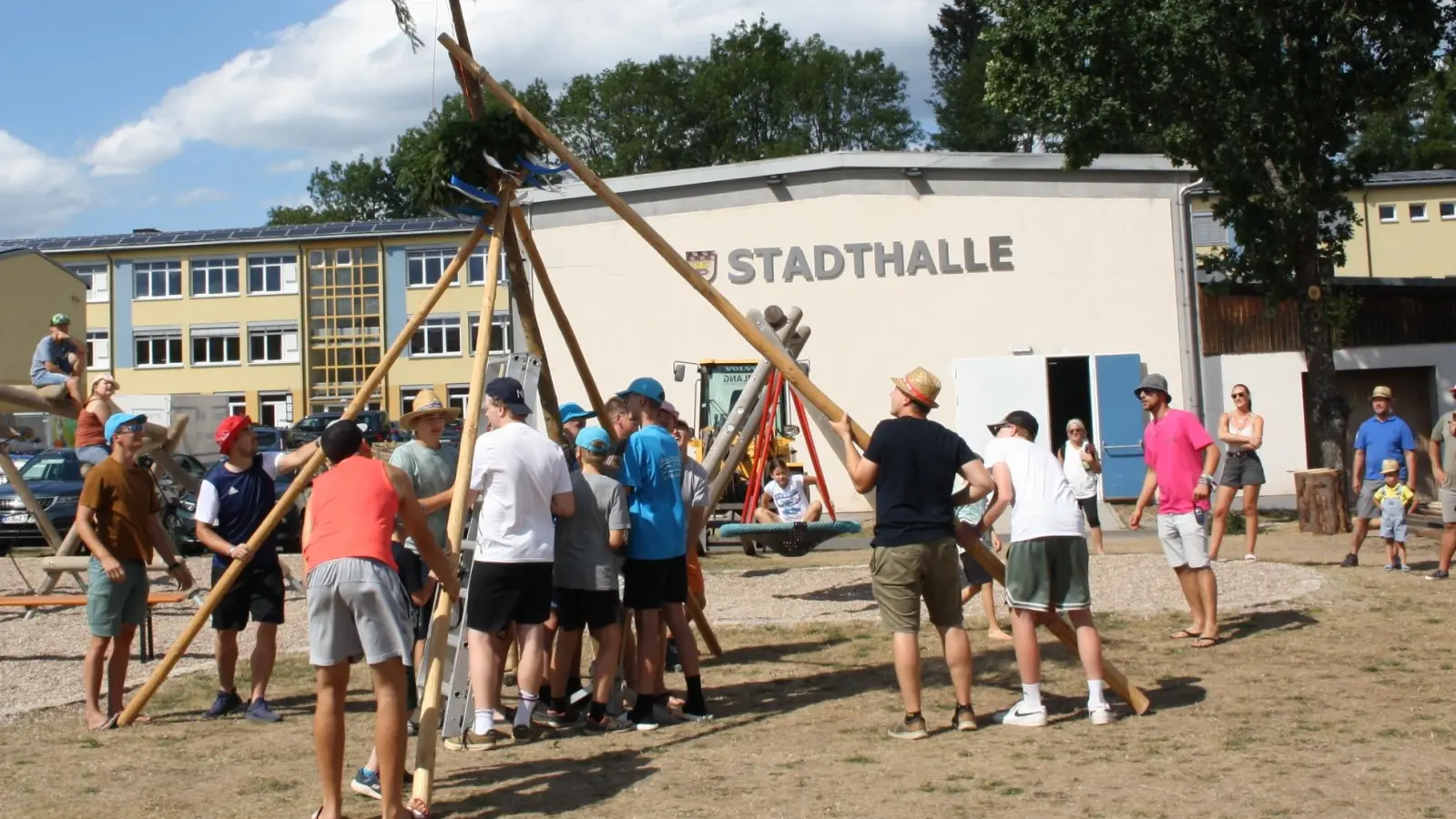 Aus Sicherheitsgründen nur gute sechs Meter lang war der Kirwabaum des Gauverbands-Trachtenjugendzeltlagers in Pressath, und um kein Loch in den Boden des Rasenplatzes bohren zu müssen, hatte man einen Aufstellungsort „außerhalb” vorbereitet. Aufgerichtet wurde der Stamm allerdings ganz in traditioneller „Schwalben”-Technik. (Bild: Dr. Bernhard Piegsa)