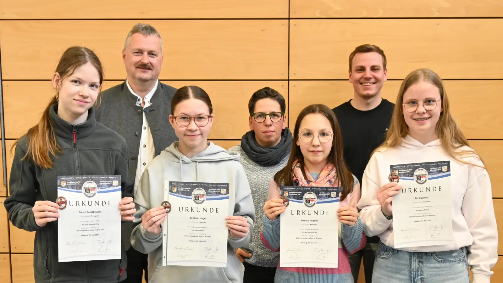 Die Vorstände Tobias Forster und Heike Schieder, sowie Dirigent Thomas Kick (zweite Reihe von links) gratulieren Sarah Ernstberger, Sophia Langer, Paula Schieder und Pia Fichtner zum Leistungsabzeichen in Bronze. (Bild: Kerstin Kiener)