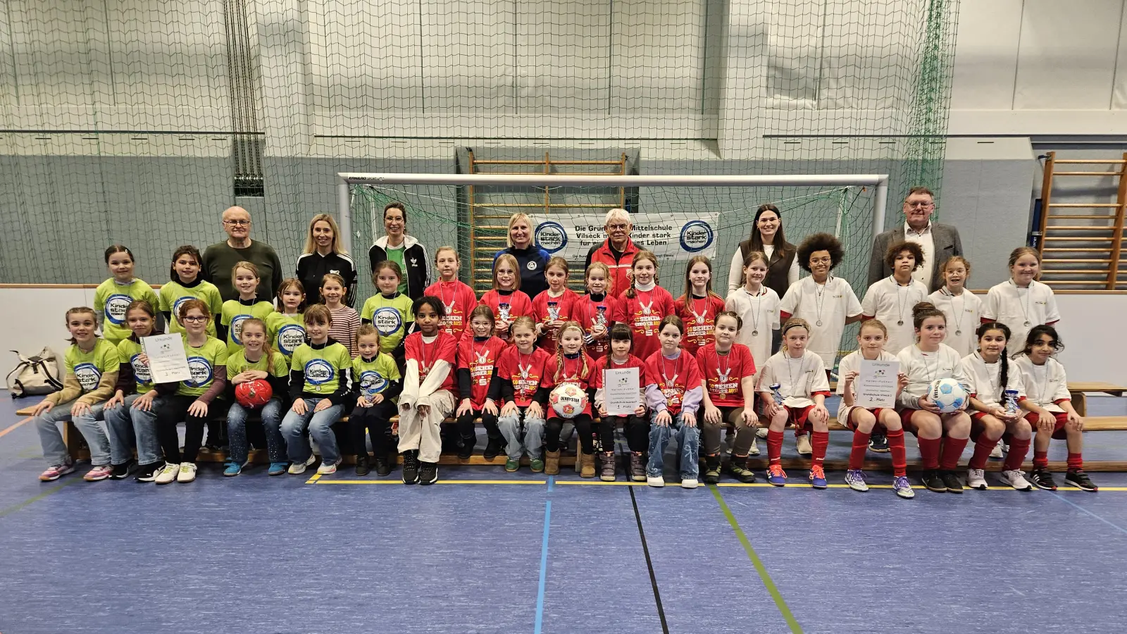 Die drei Mädchen-Mannschaften der Hallen-Fußball-Landkreismeisterschaft der Grundschulen von links: 3. Poppenricht, 1. Auerbach und 2. Vilseck mit (hinten von links) Mädchen-Fußball-Obmann Karl Heinz Grollmisch, Susanne Engelhardt und Rektorin Janina Schmidt (beide Poppenricht), Lehrerin Sabine Biersack, Schiedsrichter Christian Trummer, Lehrerin Julia Kroher (Vilseck) und Bürgermeister Hans-Martin Schertl. (Bild: Christine Grollmisch)