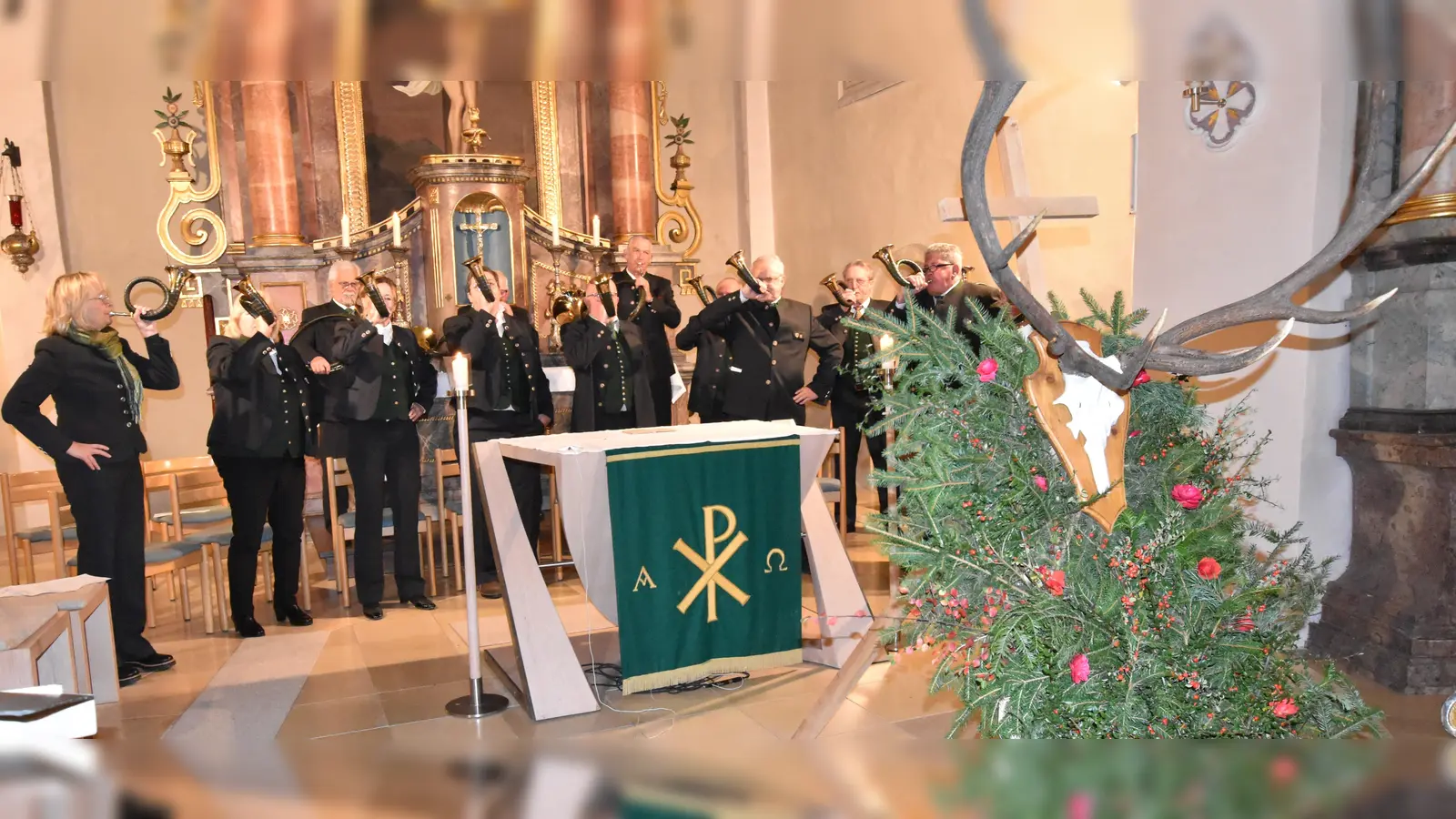 Die Jagdhornbläsergruppe der BJV Kreisgruppe sorgte für die würdevolle musikalische Gestaltung des Gottesdienstes, aus Anlass der Hubertusfeier, in der St.Veit-Kirche in Illschwang; (rechts zu sehen): das Bildnis eines Hischkopfs, mit mächtigem Geweih und einem dazwischen platzierten Kreuz, mit Bezug zum Leben des Heiligen Hubert. (Bild: Norbert Weis)