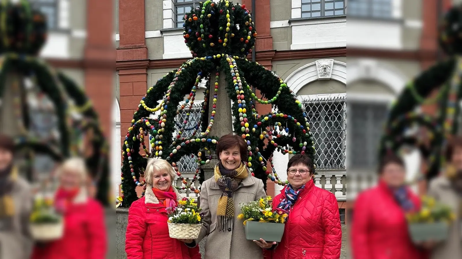V.l.n.r. Gabi Fröhlich, Zweite Bürgermeisterin Tanja Kippes und Meta Fichtner vor dem Osterbrunnen am Stadtplatz in Neustadt/WN. (Bild: Ramona Herrmann)