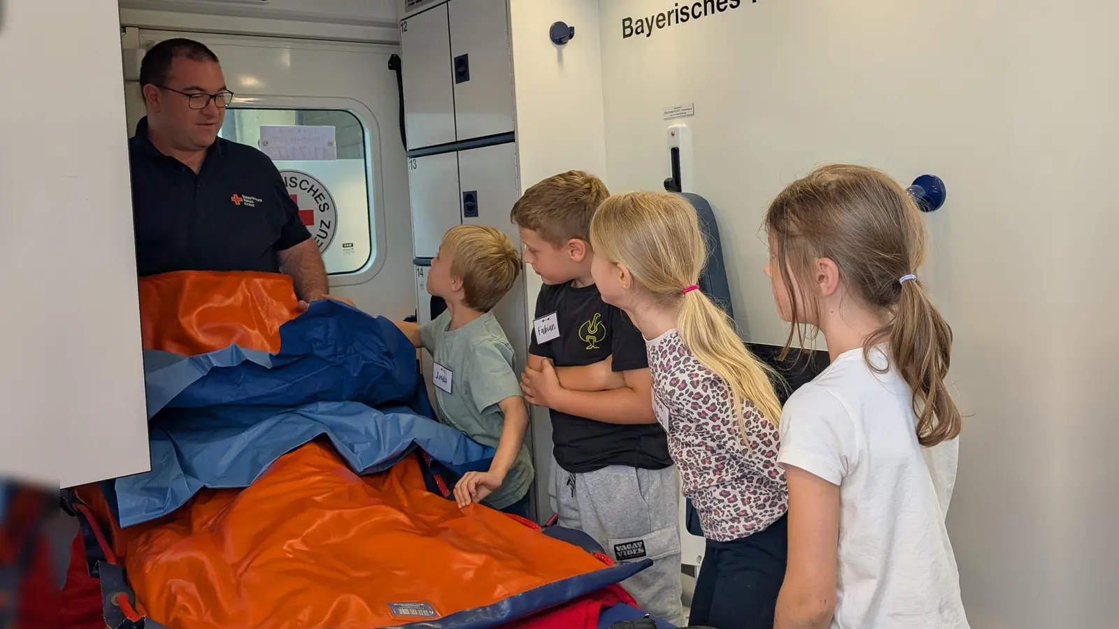 Bereitschaftsleiter Thomas Wagner mit einer Gruppe beim Besichtigen des Rettungswagens. (Bild: Maria Wagner)