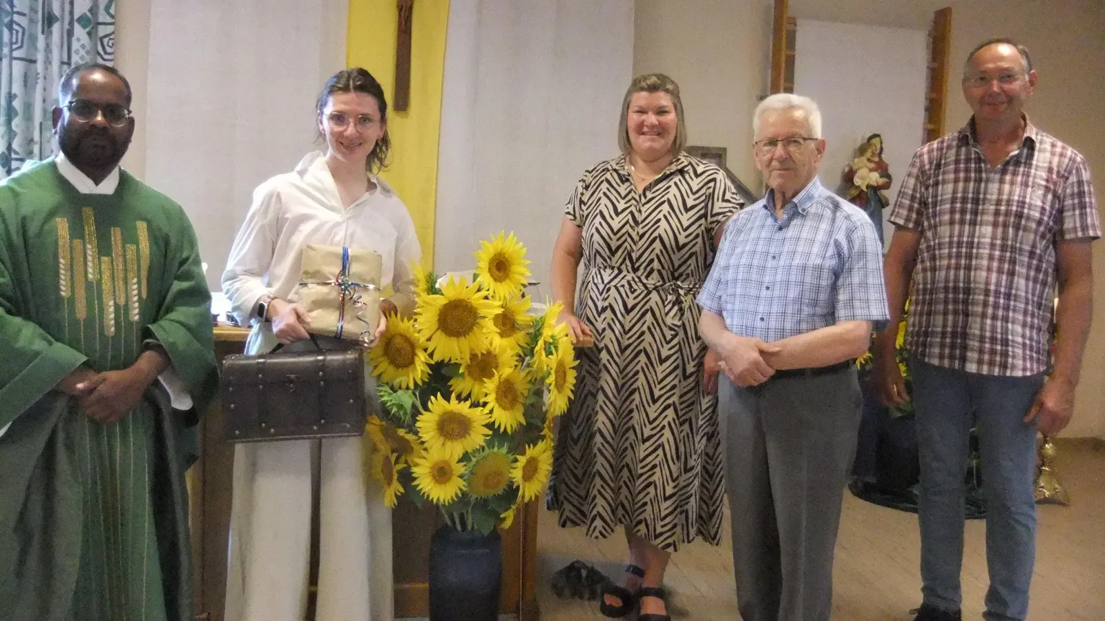 Der Abschied von Gemeindeassistentin Sarah Koch am Pittersberg wurde quasi aufgrund immer guter Zusammenarbeit mit besonders schönen Sonnenblumen bereichert. Alle in der Nikolauspfarrei und auch darüber hinaus, sind dabei sichtlich gute Freunde geworden. Ein Wiedersehen hat man sich daher versprochen. Von links: Pfarrer Robin Sagai, Sarah Koch mit ihrem Schatzkästlein (vorne zu sehen), Gemeindereferentin Kathrin Blödt, Ruhestandspfarrer Josef Beer und Kirchenpfleger Josef Schlegl, der letztlich Kirchlich rundum für alles sorgt.  (Bild: Michael Götz)