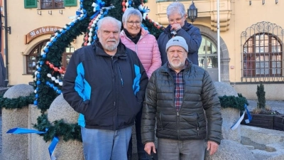 Mit vereinten Kräften hievten die Mitglieder der Siedlergemeinschaft Vohenstrauß die Osterkrone mit gut 1000 Eiern in den Farben der Stadt auf den Granitbrunnen vor dem Rathaus. (Bild: Martin Licha)