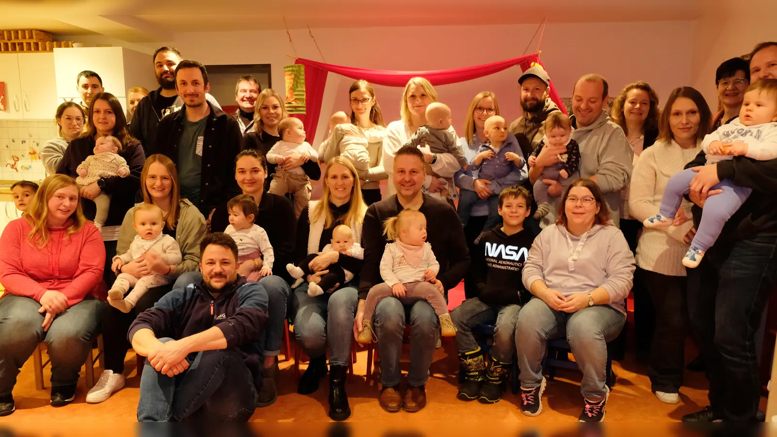 Im Mini-Club im Untergeschoss des Vorbacher Gemeindezentrums machten sich beim Neugeborenen-Empfang der Gemeinde die 14 jungen Familien schon einmal mit den Betreuungsmöglichkeiten vertraut. Unser Bild zeigt die Gäste mit den Gastgebern.  (Bild: Robert Dotzauer)