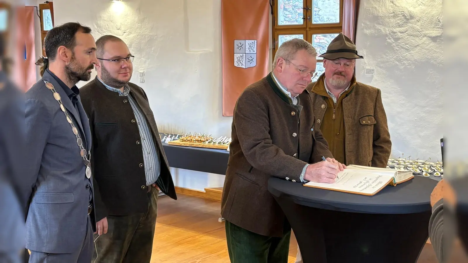 Präsident Ernst Weidenbusch beim Eintrag in das Goldene Buch der Marktgemeinde Moosbach (v. l. n. r.): Bürgermeister Armin Bulenda, 1. Vorsitzender der BJV Kreisgruppe Vohenstrauß Michael Kraus, der Präsident des Bayerischen Jagdverbands Ernst Weidenbusch und Severin Wejbora, Leiter der Landesjagdschulen Bayern. (Bild: Florian Forster)