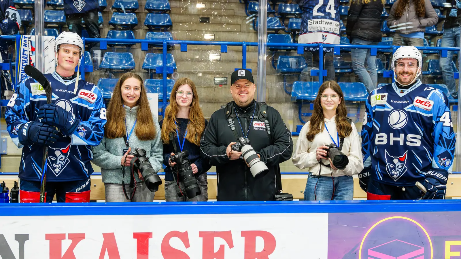 Erinnerungsfoto vom Besuch bei den Blue Devils Weiden: Schülerinnen der Foto-AG der Lobkowitz-Realschule mit den Eishockeyspielern Noah Samanski (l.) und Fabian Ribnitzky (r.) sowie ihrem Lehrer Tobias Neubert (3. v. l.). (Bild: Elke Englmaier)