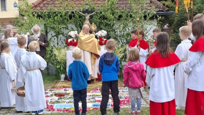Prälat Dr. Josef Ammer erteilte den Gläubigen an den vier Altären den eucharistischen Segen. Den Altar beim Backofen hatten wieder die Ministranten in Pizzaschachteln farbenfroh gestaltet. (Bild: Martin Staffe)