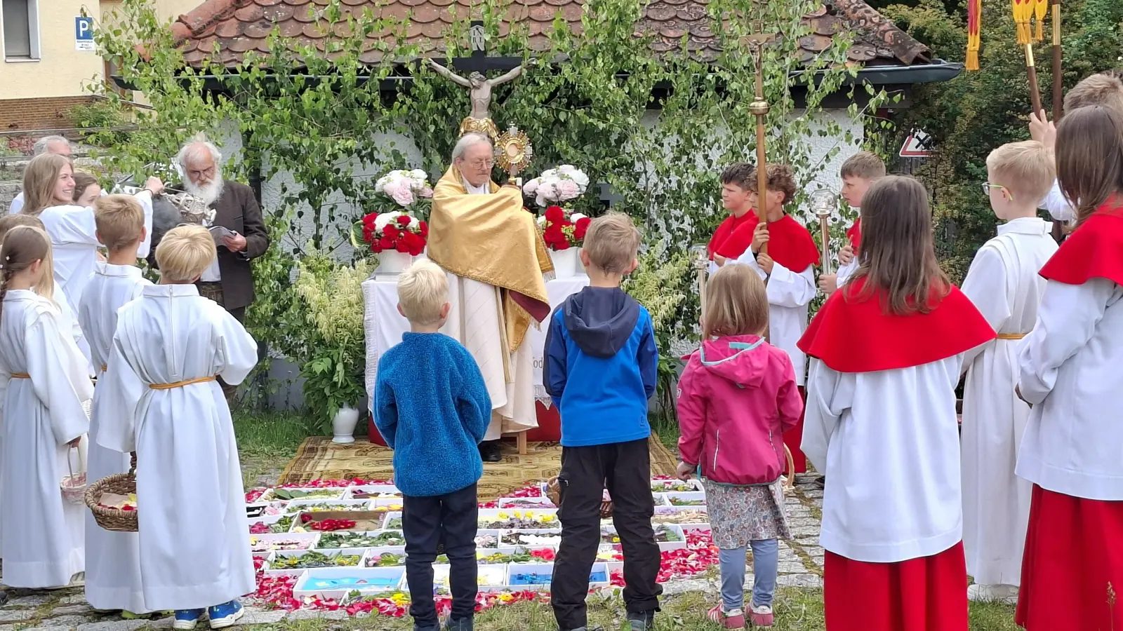 Prälat Dr. Josef Ammer erteilte den Gläubigen an den vier Altären den eucharistischen Segen. Den Altar beim Backofen hatten wieder die Ministranten in Pizzaschachteln farbenfroh gestaltet. (Bild: Martin Staffe)