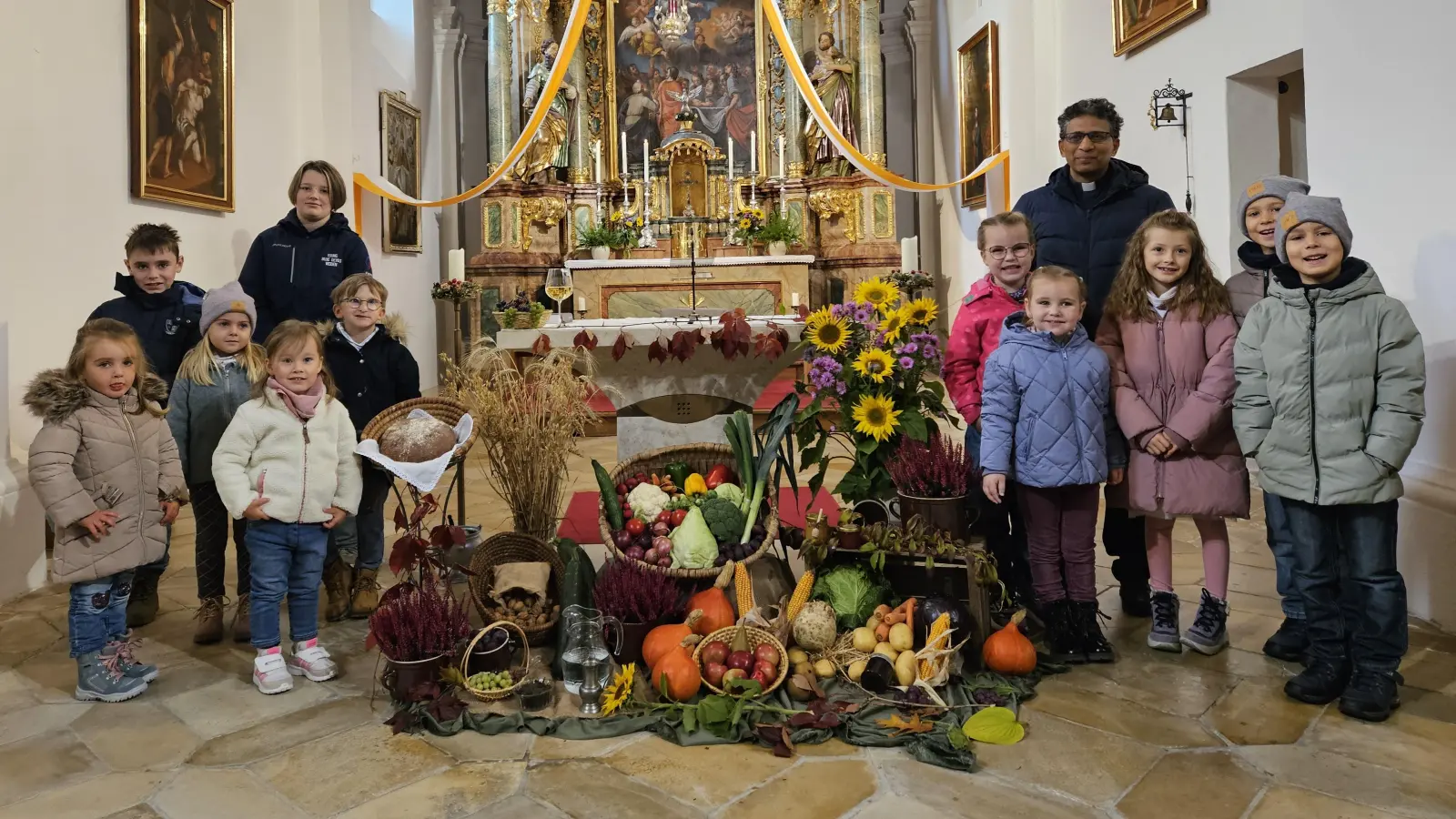 Ein ganz besonderer Sonntag - die mitwirkenden Kinder mit Pater Joseph am Erntealtar. (Bild: Gabriele Buchbinder)