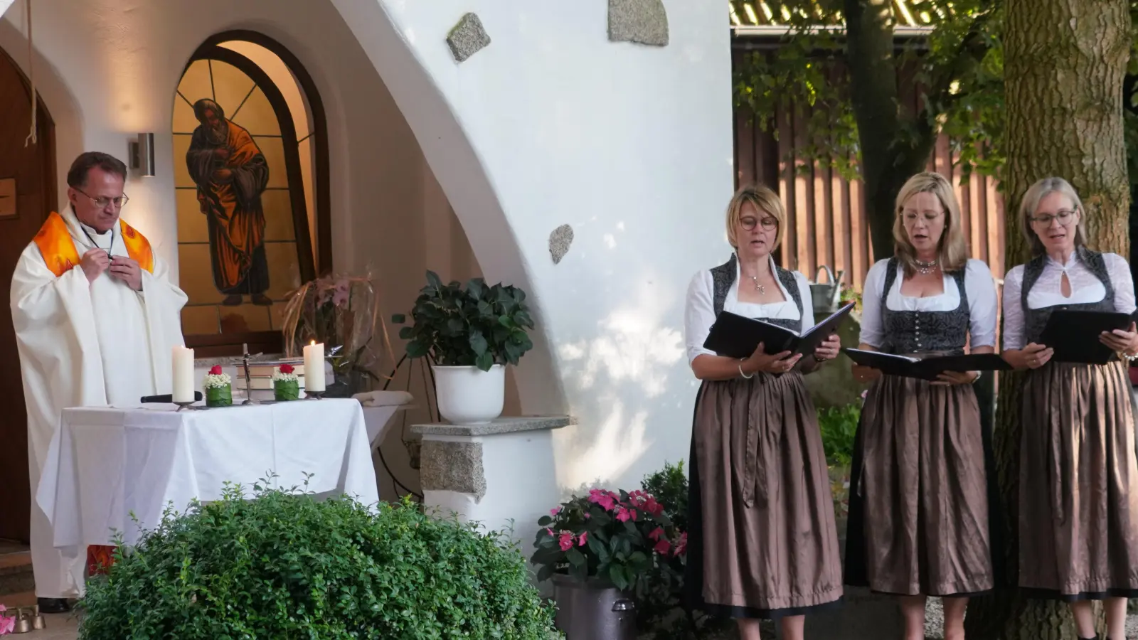Pfarrer Alexander Hösl zelebriert die Patroziniumsmesse der Christophoruskapelle der Familie Wildenauer in Straßenhäuser. Die Waldthurner Gesangsgruppoe TriAngel mit Andrea Götz, Steffi Daubenmerkl und Doris Völkl (von links) umrahmt zusammen mit dem Leuchtenberger Liederkranz die Messe. (Bild: Franz Völkl)