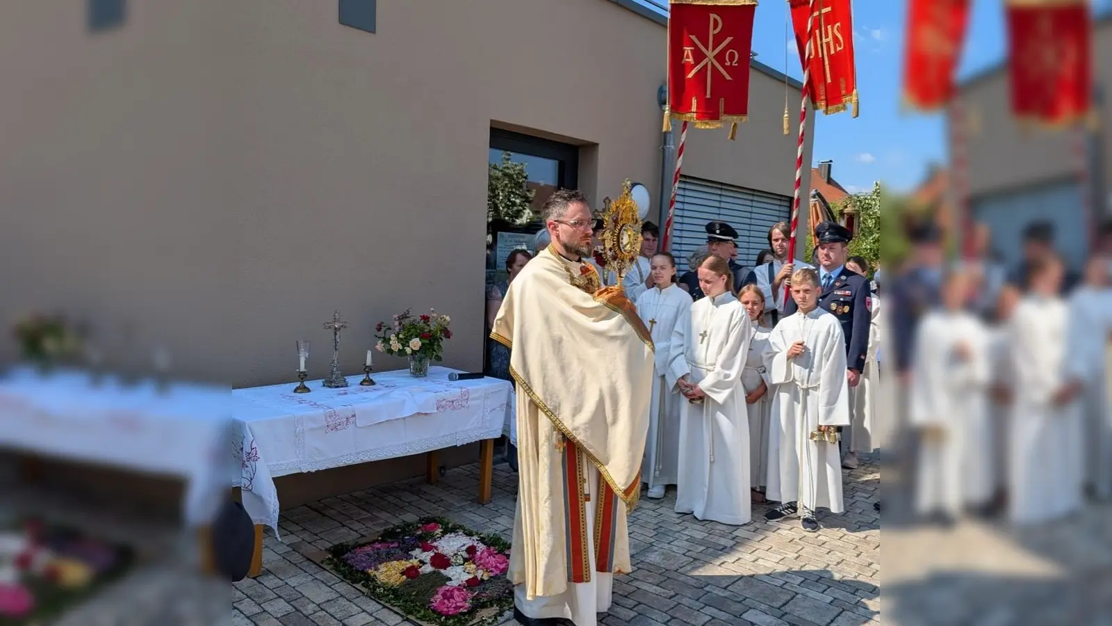 Auch die Bewohner und Mitarbeiter der BRK-Senioreneinrichtung „Am Nussbaumpark” beteiligten sich an der Prozession zu Fronleichnam. Vor dem neueröffneten Tagescafé wurde der Segen mit dem Allerheiligsten gespendet. (Bild: Manuela Popp)