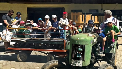 Traktor fahren ins Dschungelcamp. Bauer Fritz selbst setzte sich ans Steuer, die Kinder drängten sich auf den Anhänger und johlten, als der Traktor über den Feldweg rumpelte. (Bild: Romy Hösl)
