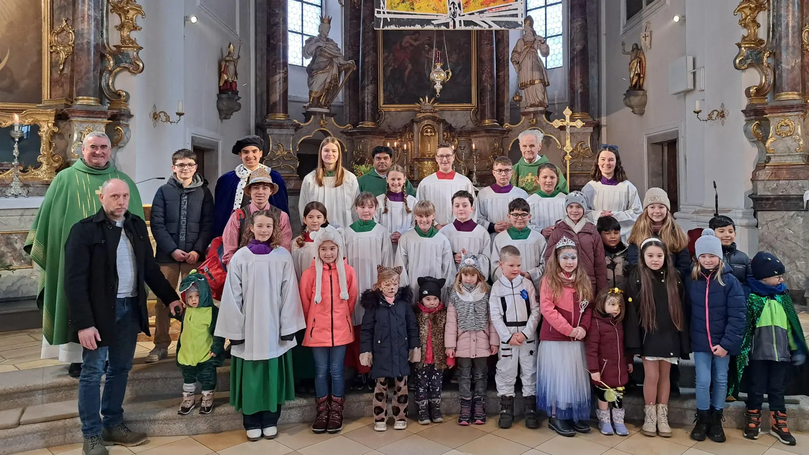 Fröhliche Gesichter und bunte Kostüme: Pfarrer Alfons Kaufmann, Pfarrer Lothar Kittelberger und Kaplan Chinna Dola mit Ministranten und verkleideten Kindern beim Familiengottesdienst. (Bild: Martin Uschold)