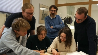 Studierende aus Jena bei der Quellenarbeit im Stadtarchiv Nabburg, beobachtet von Stadtarchivar Gotthard Kemmether (Bildmitte). (Bild: Marko Pammer)